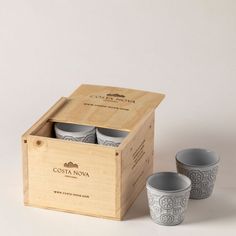 three cups in a wooden box next to each other