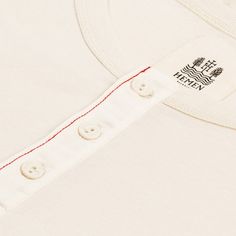 Short-sleeve henley.
Made of 180 g/㎡ organic cotton 1x1 rib jersey.
Adjusted fit.
Cotton button tape and red overstitch.
100% "GOTS" certifed organic cotton.
Quality garments made in Portugal. White Cotton T-shirt With Henley Neckline, Classic Cotton Henley, Classic Cotton Henley With Buttons, Cotton Henley T-shirt With Buttons, Cotton Henley Neckline T-shirt With Buttons, White Cotton Henley With Buttons, White Henley Neckline Cotton T-shirt, White Cotton Henley Neckline T-shirt, Cotton Henley For Everyday Wear