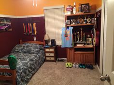 a bedroom with a bed, dresser and shelves filled with sports memorabilia on the wall