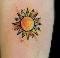 a sun tattoo on the back of a woman's leg with watercolors