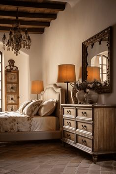 a bedroom with a bed, dresser and mirror on the wall next to two lamps