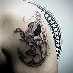 a man's shoulder with a deer and bird tattoo on it