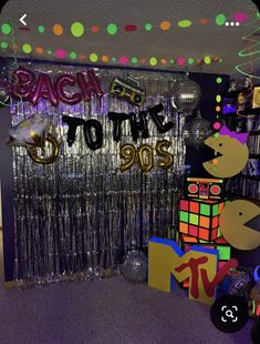 a room filled with disco balls and streamers that say back to the 90's