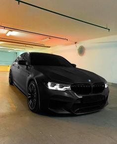 a black car is parked in an empty parking garage