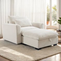 a white chair sitting on top of a rug next to a window