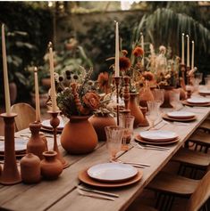 a long table with plates and vases on it