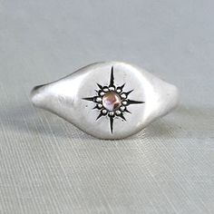 Star Signet Ring with Peach Pink Sapphire Oval Silver Signet Ring For Promise, Adjustable Silver Signet Ring With Gemstone, Celestial Sterling Silver Signet Ring For Anniversary, Sterling Silver Star Shaped Signet Ring For Anniversary, Sterling Silver Star-shaped Signet Ring For Gift, Silver Celestial Signet Ring As Gift, Silver Celestial Style Signet Ring For Gift, Celestial Silver Signet Ring, Celestial Silver Signet Ring For Gift