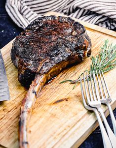 a steak on a cutting board with a fork and knife