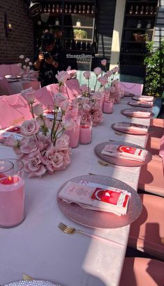 the table is set with pink flowers and candles