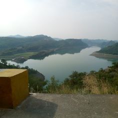 a bench sitting on the side of a cliff overlooking a lake