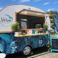 the food truck is decorated with tropical leaves