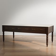 a wooden table with two drawers on one side and a marble top on the other