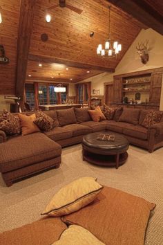 a living room filled with lots of couches and pillows on top of carpeted flooring