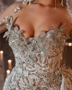 the back of a woman's wedding dress with beading and crystals on it