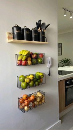 two metal baskets filled with fruit on top of a wall