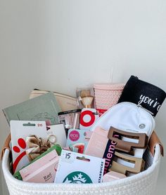 a white basket filled with lots of different types of cards and other items on top of a table