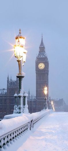 the big ben clock tower towering over the city of london covered in snow