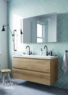 a bathroom with a sink, mirror and towel rack on the wall in front of it