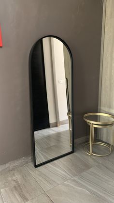 a mirror sitting on the floor next to a table