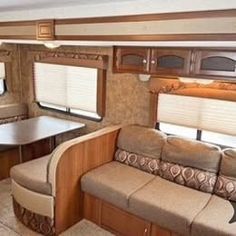 the inside of an rv with couches and tables