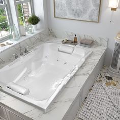 a large white bath tub sitting next to a window