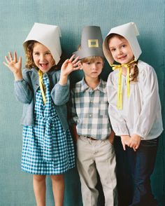 three children wearing paper hats standing next to each other