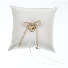 a white pillow with a heart and initials tied to the side, on a white background