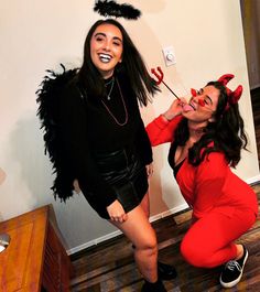 two women dressed in devil costumes posing for the camera, one with her mouth open