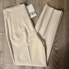 Pants With A High Waist And Pronounced Seams At Front And Back. Front Welt Pockets. Front Zip, Metal Hook, And Interior Button Closure. Measurements Size - Small Waist - 13” Rise - 12” Length - 26” Color - Oyster White Size - Small Condition - Nwt Cream Tapered Leg Bottoms For Spring, Chic Cream Tapered Leg Bottoms, Chic Cream Tapered Leg Pants, Cream High Waist Stretch Pants, Cream Color High Waist Stretch Pants, High Waist Stretch Cream Pants, Chic Cream Ankle-length Bottoms, Cream Stretch Straight Leg Pants, Cream Stretch Pants For Spring