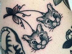 a close up of a person's leg with tattoos on it and cats in the background