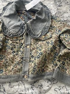 an old jean jacket with floral designs on it