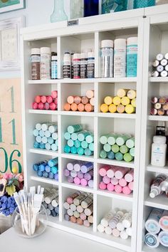 a shelf filled with lots of different types of crafting supplies on top of a white table