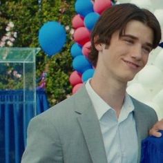 a man and woman standing next to each other in front of balloons