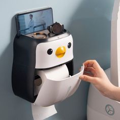 a penguin toilet paper dispenser attached to the wall