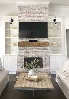 a living room filled with furniture and a flat screen tv mounted on the wall above a fireplace