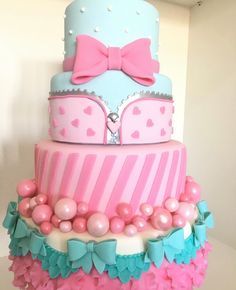 a three tiered cake with pink and blue decorations