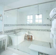 a white bath tub sitting next to a walk in shower