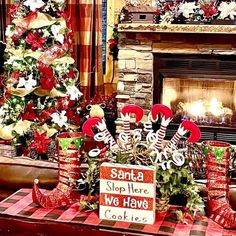 christmas decorations in front of a fireplace with santa's help we have cookies sign