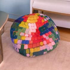 a multicolored bean bag sits on the floor next to a table and chair