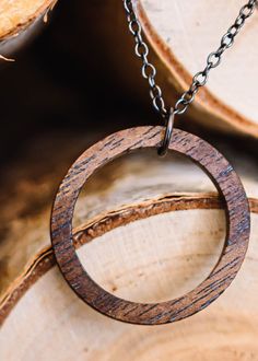 Walnut wood circle pendant is made from walnut wood that has been stained a bit darker than the natural wood. It's sanded smooth with 3 different grits of sandpaper. Chain and findings are gunmetal plated and come in 18in or 24in chain. Clasp is a spring ring. (model in pic is wearing the 18in chain). Circular pendant measures 1.25 in (33mm) Thickness of the pendant is 1/8in (3mm) approximately Please remove before showering/swimming. The polyurethane finish imparts a bit of water resistance, bu Brown Round Nature-inspired Necklaces, Nature-inspired Brown Round Necklaces, Brown Nature-inspired Round Necklaces, Rustic Round Necklace For Gift, Rustic Natural Wood Necklace, Earthy Natural Wood Jewelry For Gifts, Earthy Wooden Jewelry Gift, Earthy Wood Jewelry Gift, Earthy Wood Jewelry As Gift