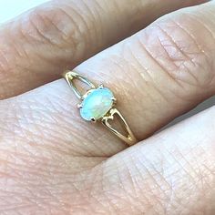 Petite Natural Oval Opal 10k Yellow Gold Ring ~ Size 6 ~ October Birthstone Ring -  ET2430 This opal has beautiful blue coloring with hints of pink. Ring Size: 6- can be resized Metal Content: 10k Yellow Gold Gemstones: Natural Opal Oval Cabochon - .23 ct Measurements: Ring face (North/South): 6mm Height of ring off of finger: 4mm Ring Shank Width: 2mm Weight: 1.27 Grams Stamps: 10k Condition: Excellent Estate Items will ship in a gift box or pouch Each piece is thoroughly examined and refinished as needed by our professional jewelers, tested to guarantee metal content,  graded by our in-house GIA (Gemological Institute of America) Graduate Gemologist, and inspected for quality before being carefully packaged and promptly shipped. Thank you for taking the time to shop with us! We have hund October Birthstone Ring, October Birthstone Rings, Ring Shank, North South, October Birthstone, Pink Ring, Yellow Gold Ring, October Birth Stone, Natural Opal