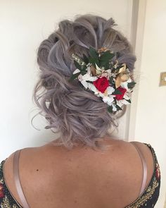 the back of a woman's head with grey hair and flowers in her hair