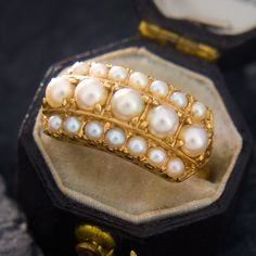 This majestic ring contains two rows of seed pearls encompasing a centered row of larger round pearls. The larger inner pearls and the smaller outer pearls are very well matched. The ring is crafted in buttery 18k yellow gold and is currently a size 6.5. Luxury Baroque Pearl Ring For Anniversary, Luxury Heirloom Pearl Ring, Luxury Timeless Open Pearl Ring, Vintage Pearl And **** Ring, Luxury Yellow Gold Pearl Ring With Brilliant Cut, Luxury Elegant Hallmarked Pearl Ring, Luxury Timeless Yellow Gold Pearl Ring, Chunky Pearls, Pearl Design