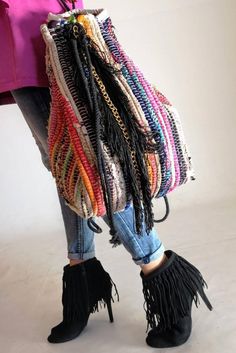 a woman's handbag with fringes and chains hanging from the front, on her legs