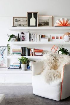 a white chair sitting in front of a book shelf