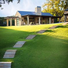 there are steps leading up to the house from the grass field in front of it