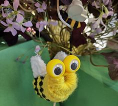 a close up of a cake topper on a table with flowers in the background