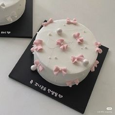 two cakes decorated with pink bows and white frosting