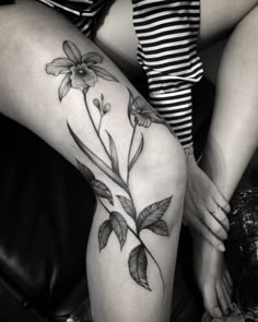 a woman's legs with flowers and leaves on them