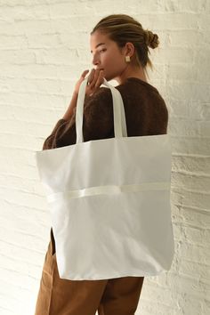 White A versatile 2-way bag that switches effortlessly from shoulder bag to handbag. Fold it and use small removable strap to pack down to a small rectangle for easy carrying. Super lightweight, durable and water resistant 1.9oz ripstop nylon (100% nylon) Zipper closure, inner zipper pocket, unlined interior shoulder bag - 18.5" (W) 19.5" (H) 5" (D) 10" drop Hand bag - 18.5" (W) 12" (H) 45" (D) 2.5" drop Made in USA Rectangular Nylon Shoulder Bag With Top Carry Handle, Nylon Shopping Bag With Detachable Strap, Large Capacity White Nylon Bags, White Nylon Shoulder Bag With Double Handle, White Nylon Shoulder Bag With Detachable Strap, White Nylon Shoulder Bag For On-the-go, Versatile White Nylon Bag, White Nylon Bag For Everyday Use, White Nylon Bag With Removable Pouch